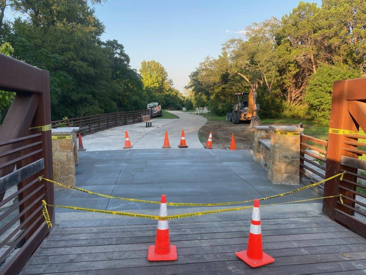two orange and white traffic cones are sitting on a bridge