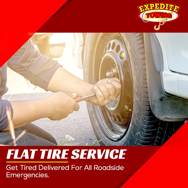 Tow truck worker tightening a car tire with a wrench, with “Flat Tire Service” roadside assistance text.