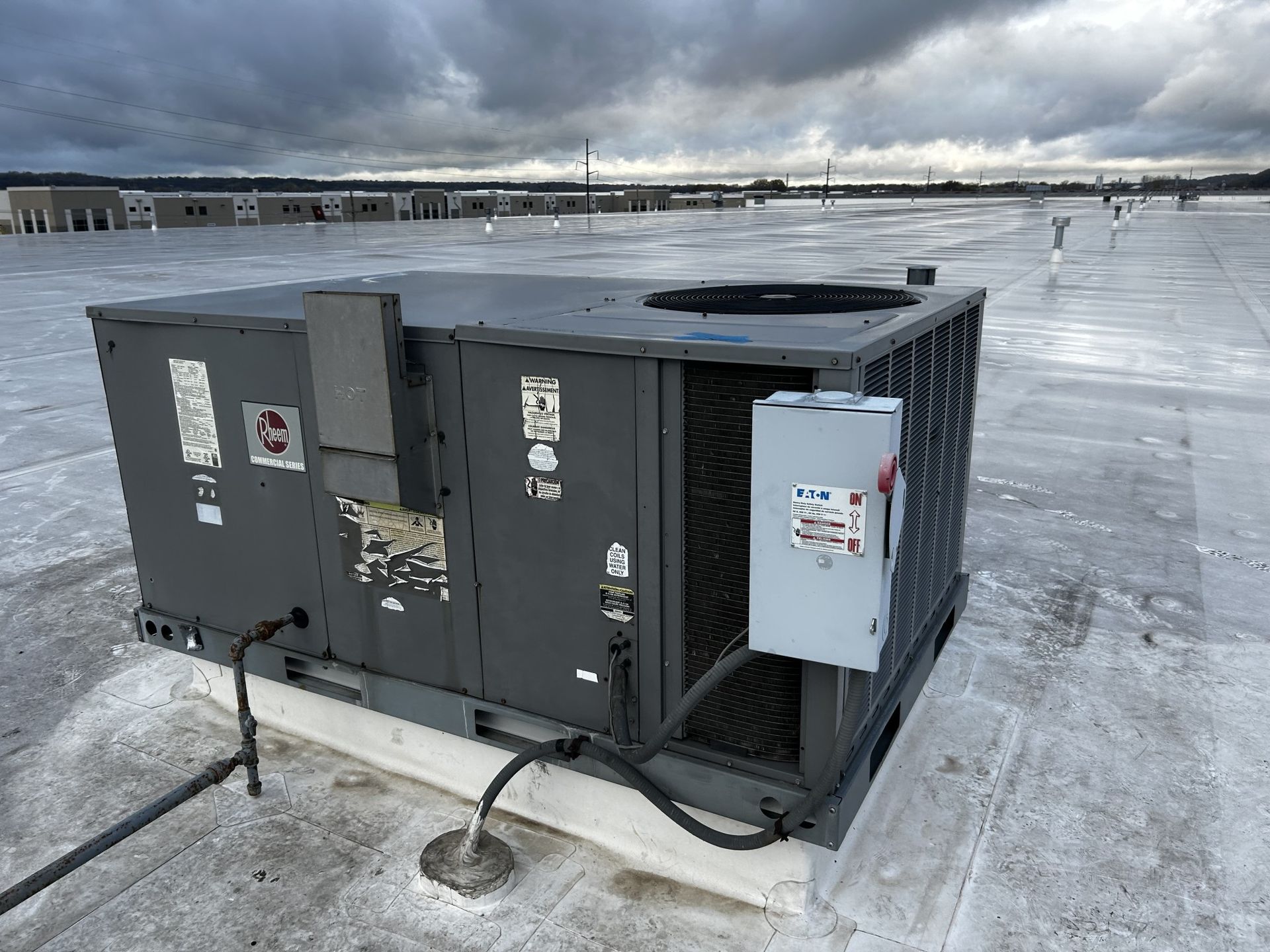 A large air conditioner is sitting on top of a roof.