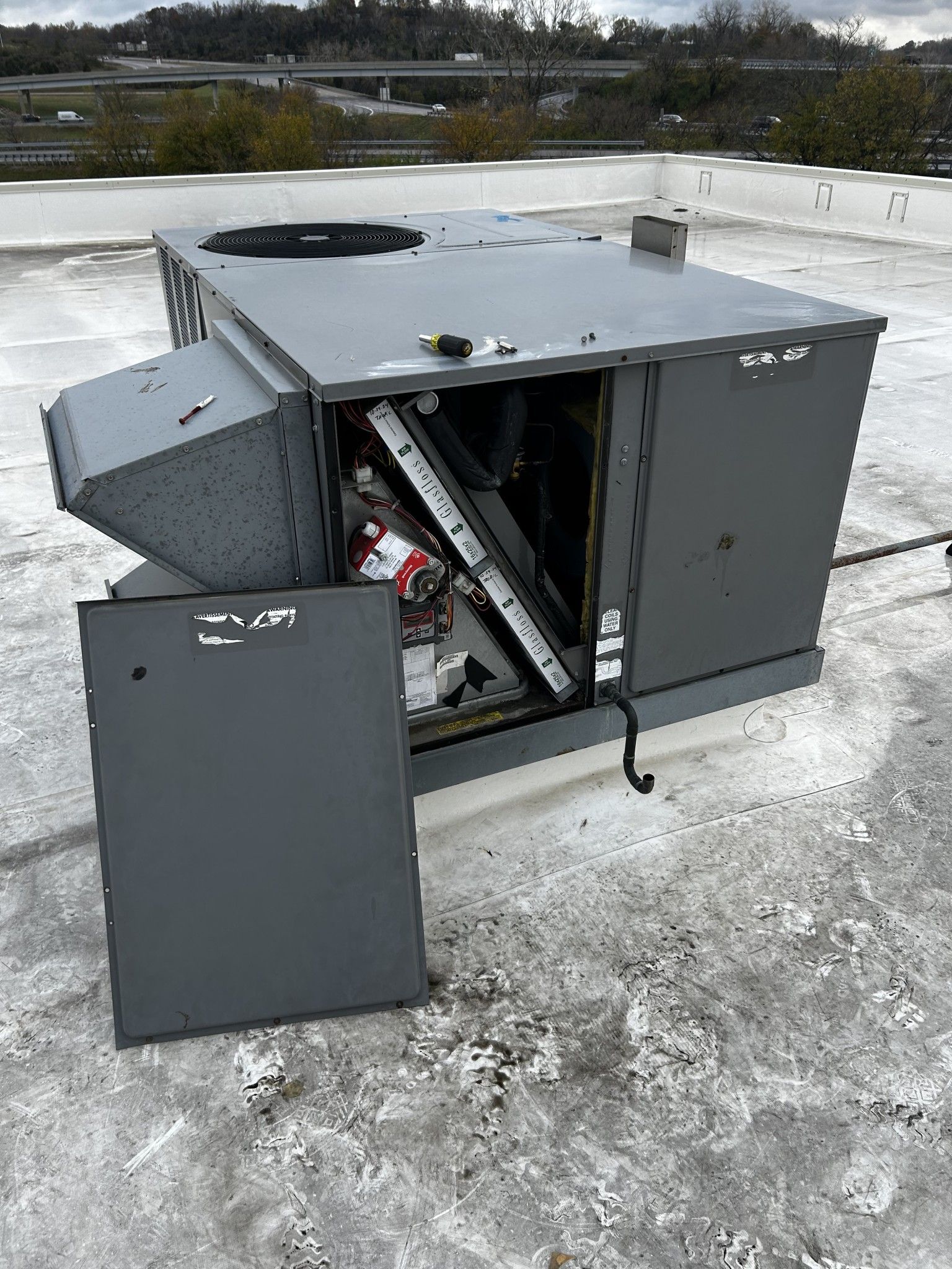 A gray box is sitting on top of a snow covered roof.