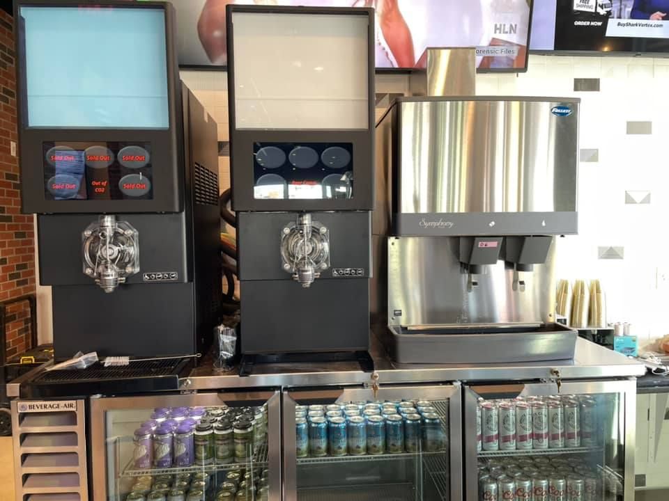 A row of drink dispensers are lined up in a restaurant