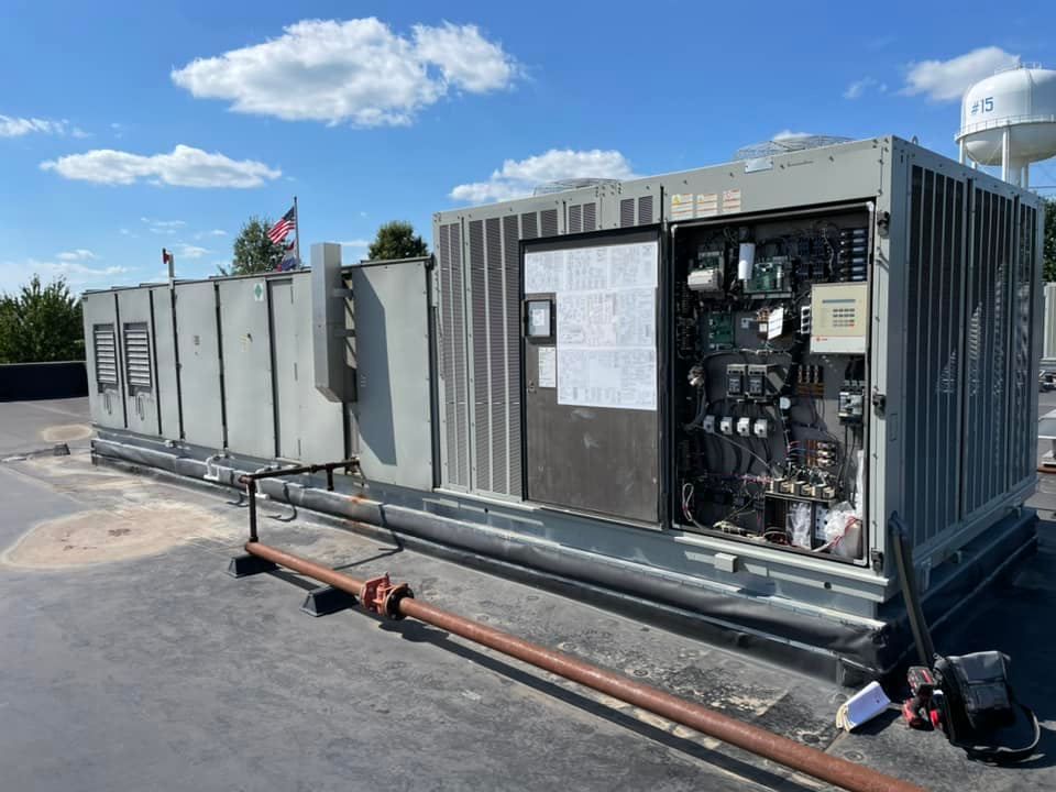 A large air conditioner is sitting on top of a roof.