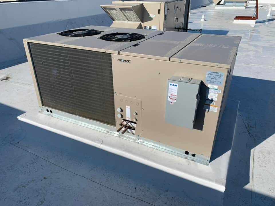 A large air conditioner is sitting on top of a roof.