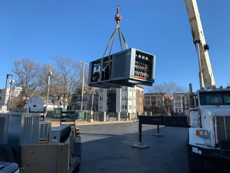 A large piece of equipment is being lifted by a crane
