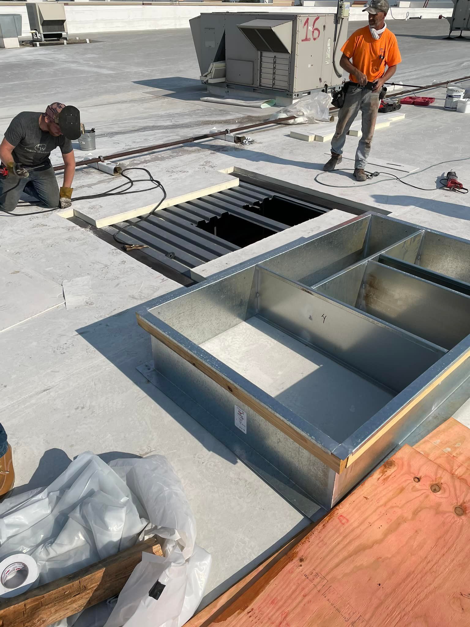 Two men are working on the roof of a building.