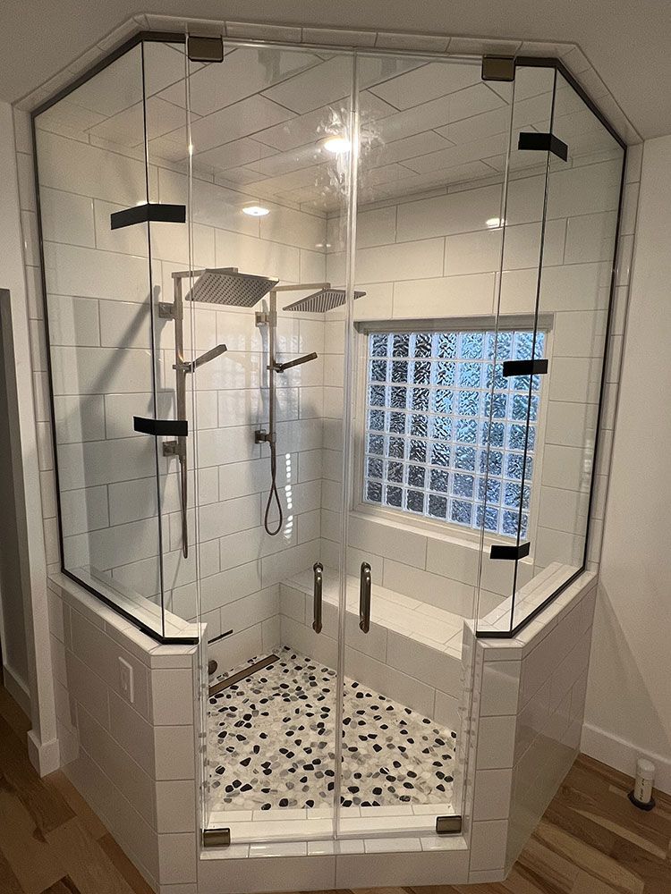 A bathroom with a glass shower door and a bathtub.