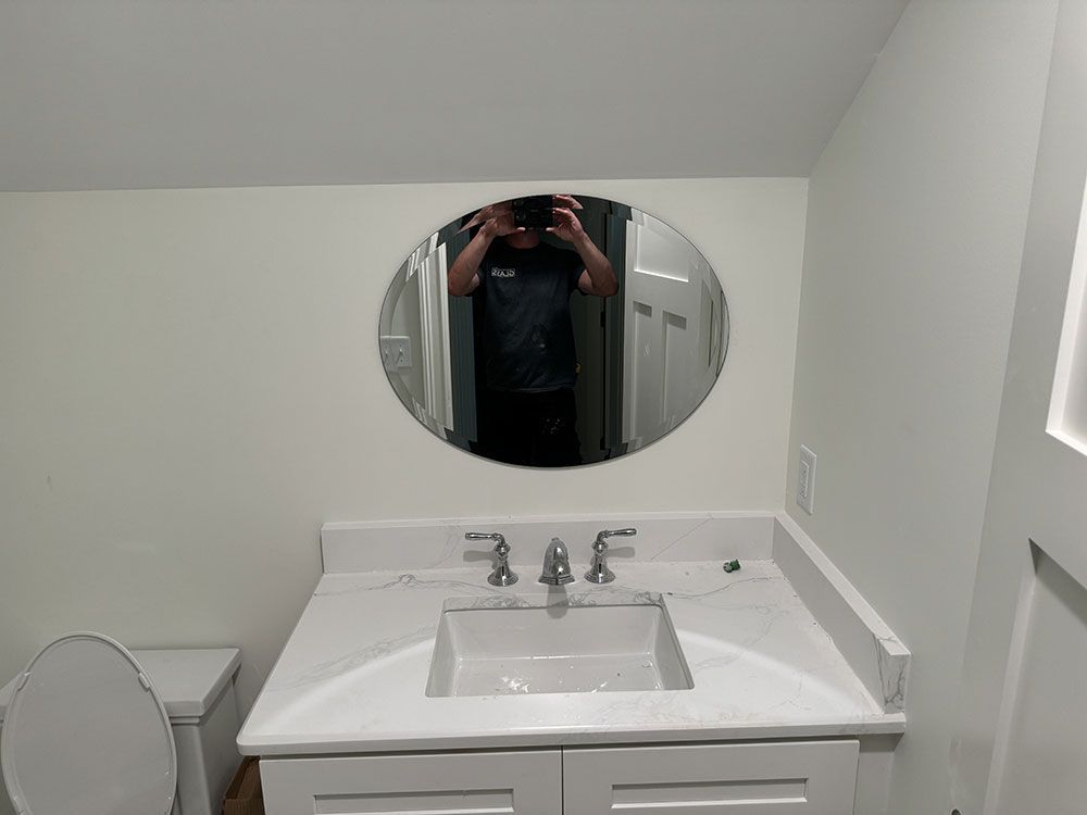 A man is taking a picture of himself in a bathroom mirror
