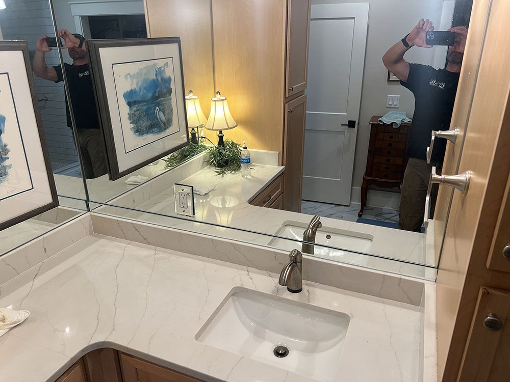 A man is taking a picture of himself in a bathroom mirror.