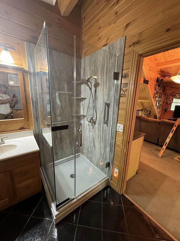A bathroom with a walk in shower and a sink.