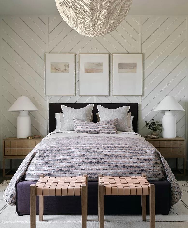 A bedroom with a bed and two benches underneath it