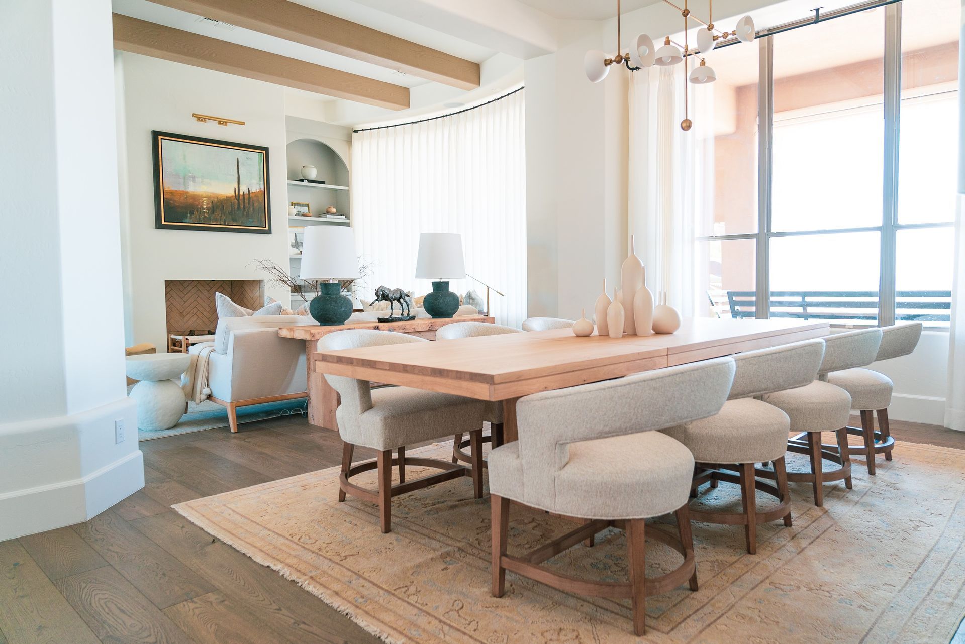 A dining room with a long wooden table and chairs.