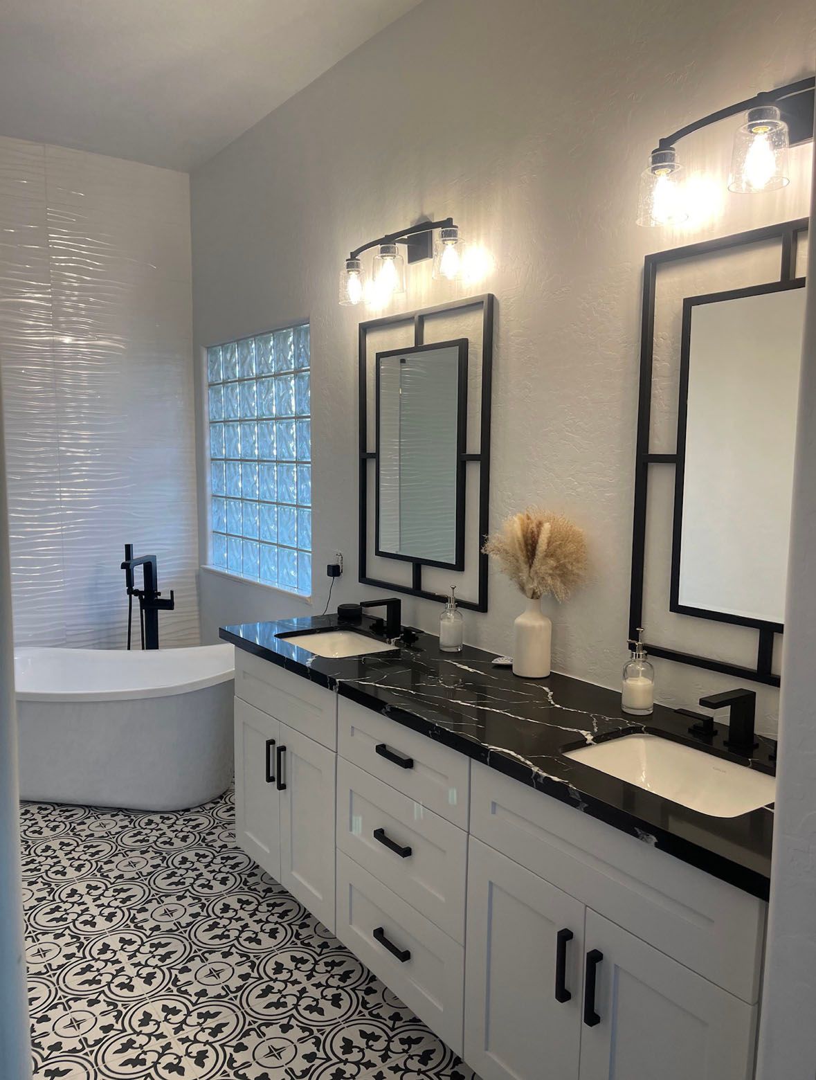 A bathroom with two sinks, two mirrors and a bathtub.