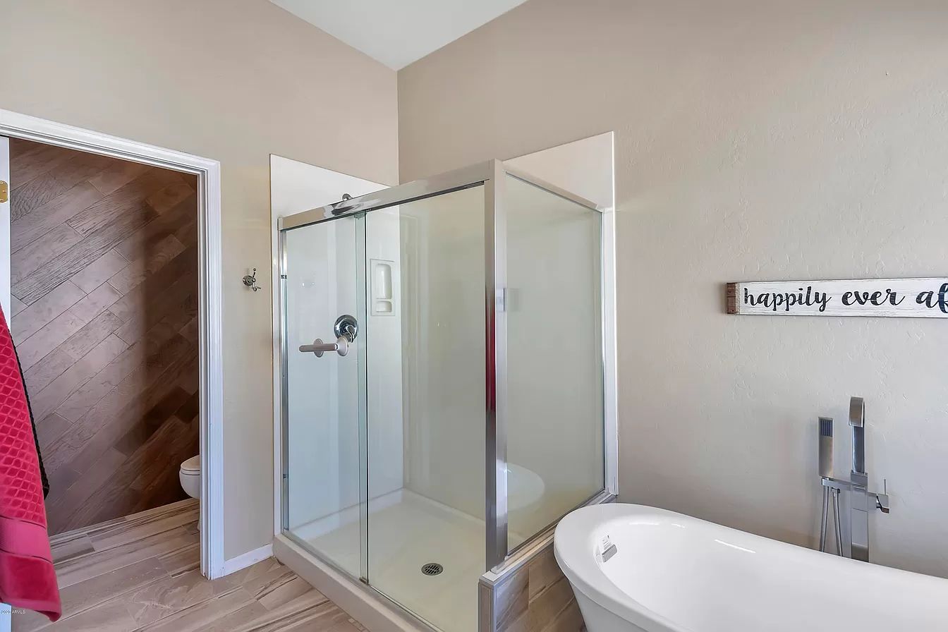 A bathroom with a walk in shower and a bathtub.