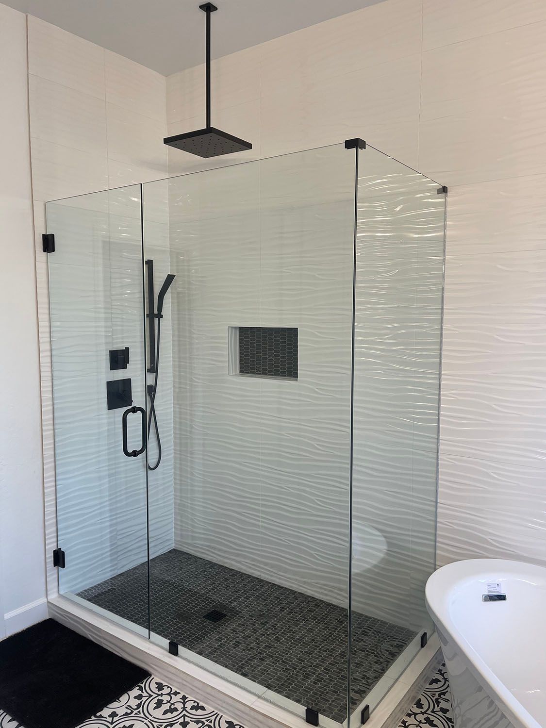 A bathroom with a walk in shower and a bathtub.