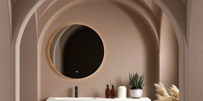 A bathroom with a sink and a round mirror on the wall.