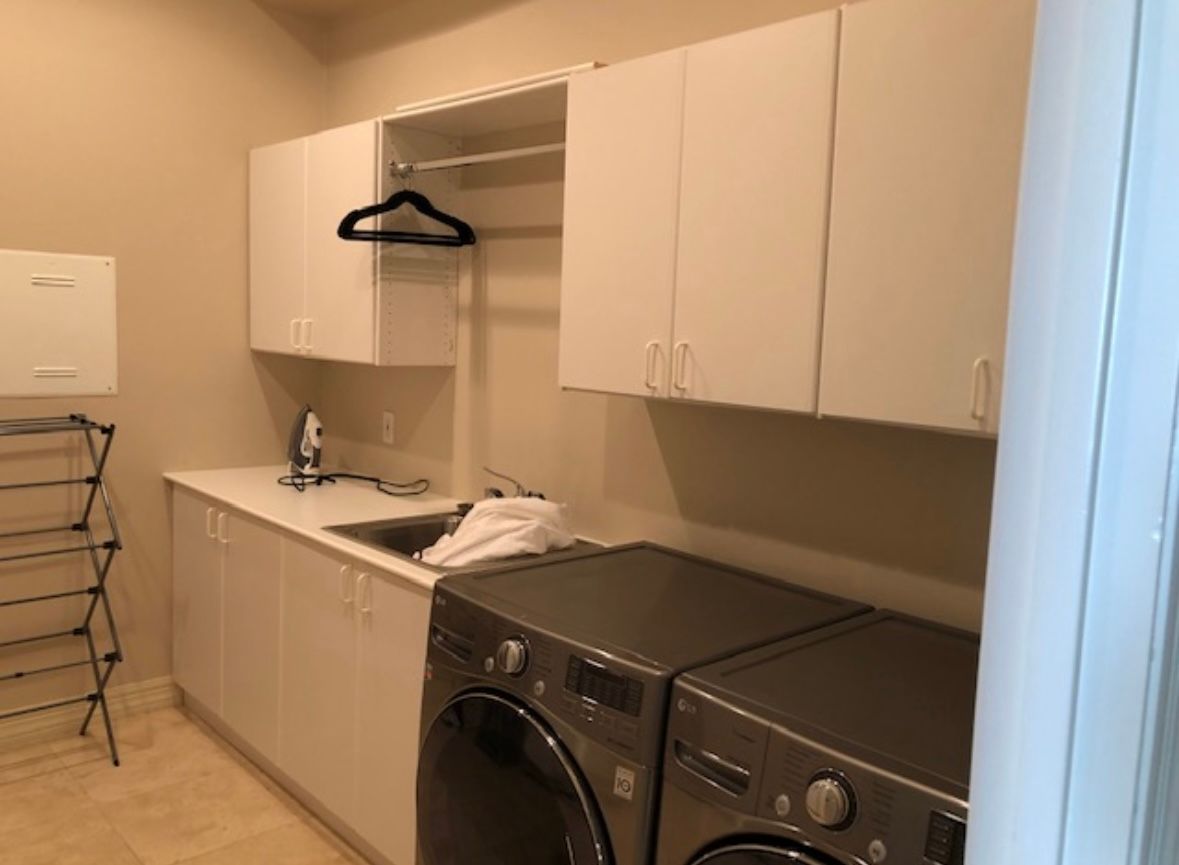 A laundry room with a washer and dryer and a sink