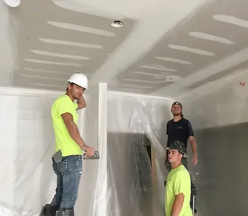 a group of men are working on a ceiling in a room 