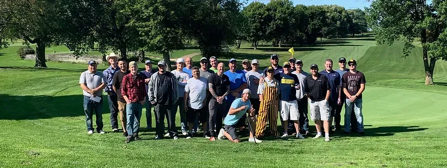 a large group of people are posing for a picture on a golf course 