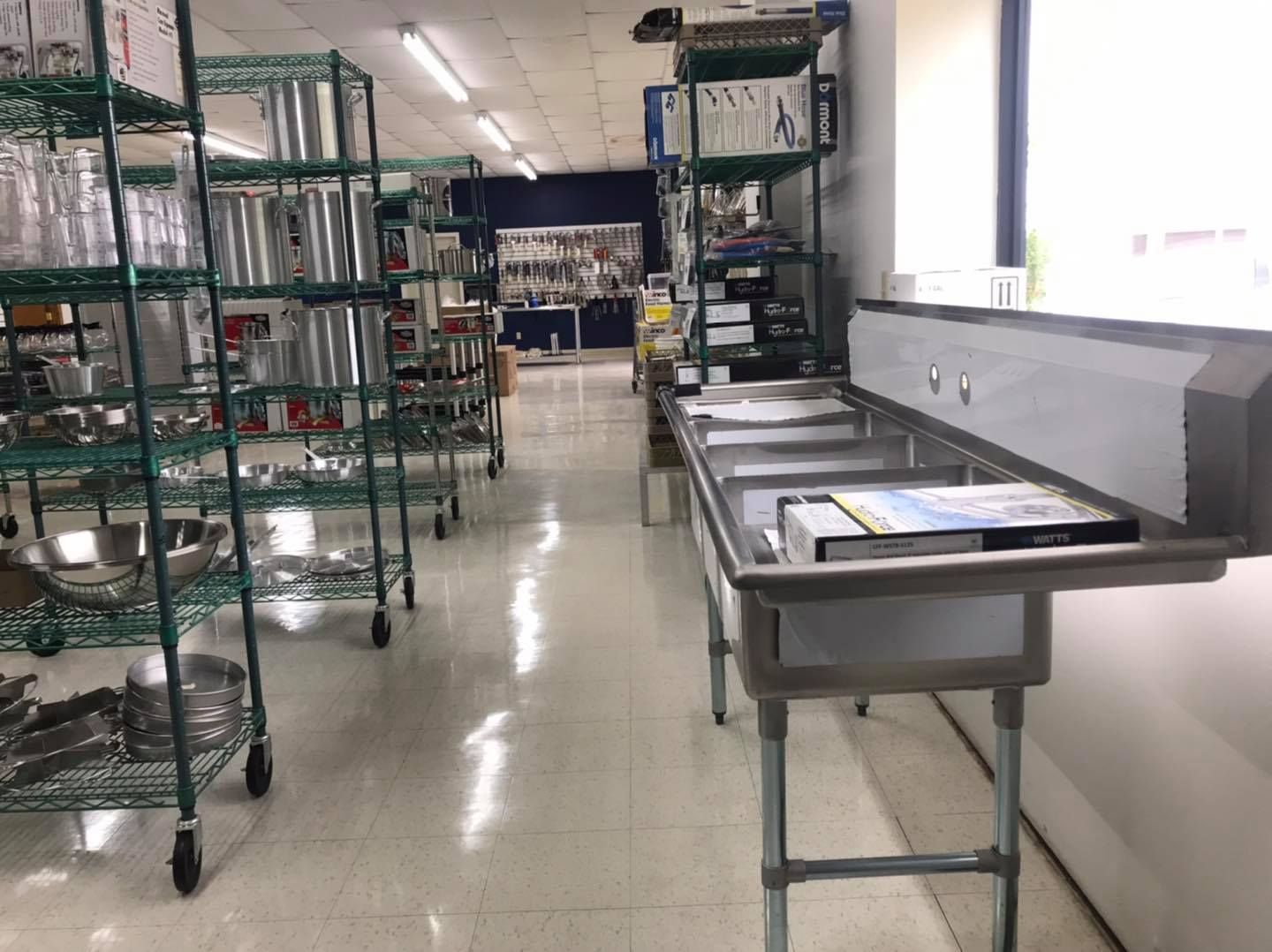 Interior of a restaurant supply store, stainless steel shelving and sinks.
