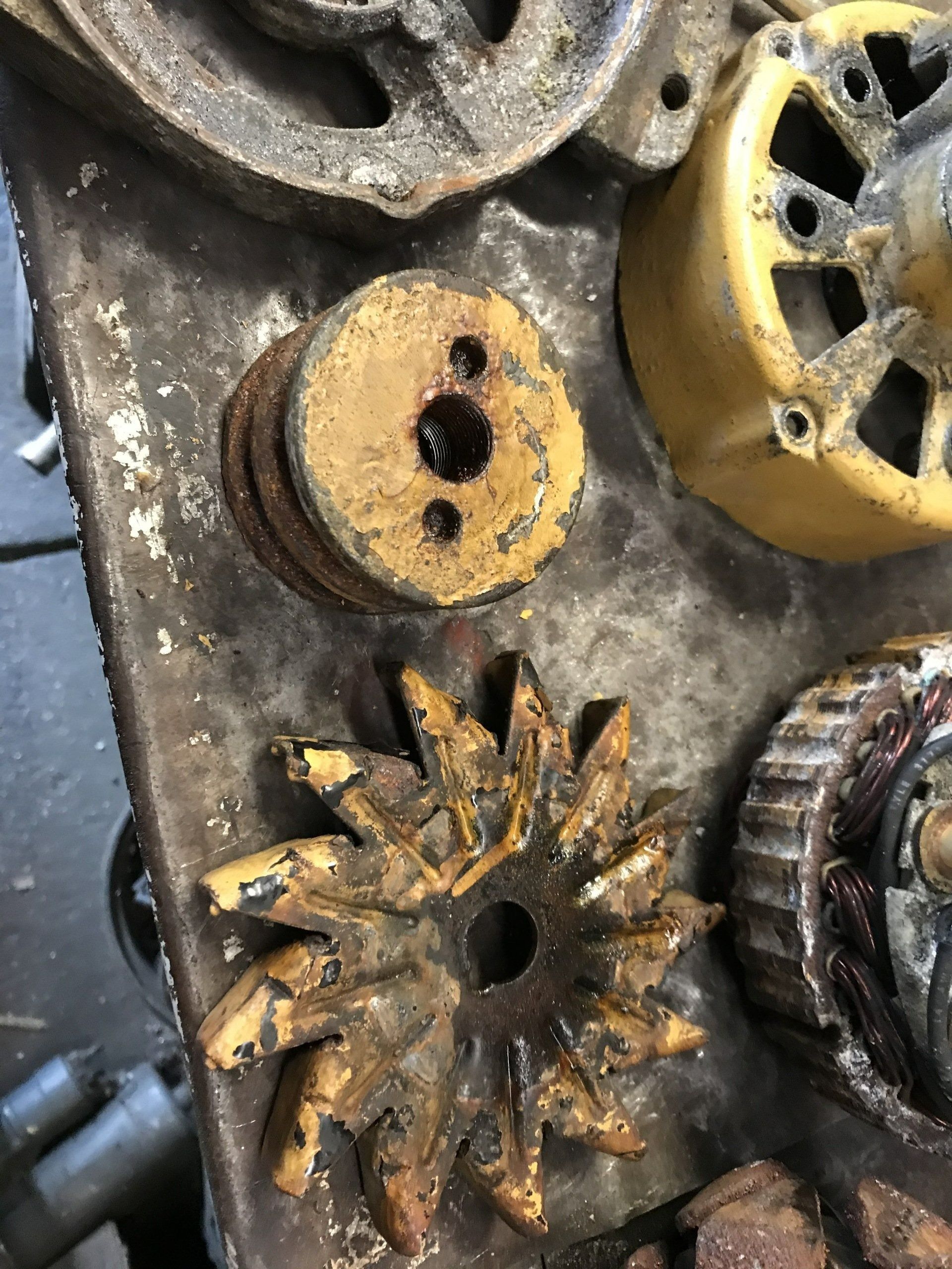 Rusty yellow and metal gears and pulleys arranged on a worn industrial surface