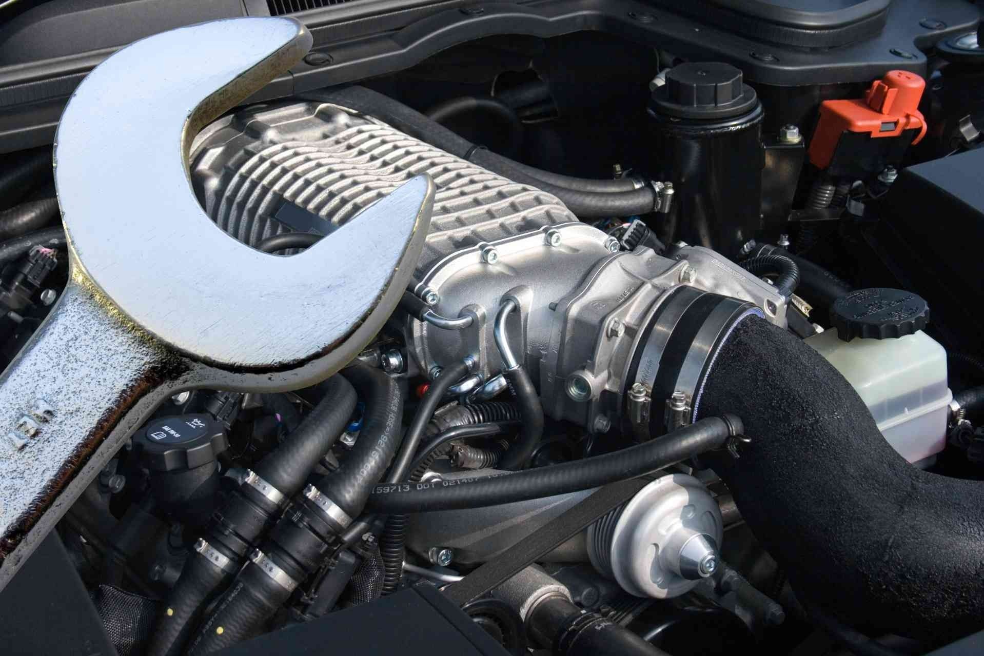 Car engine with silver intake and black hoses under the hood
