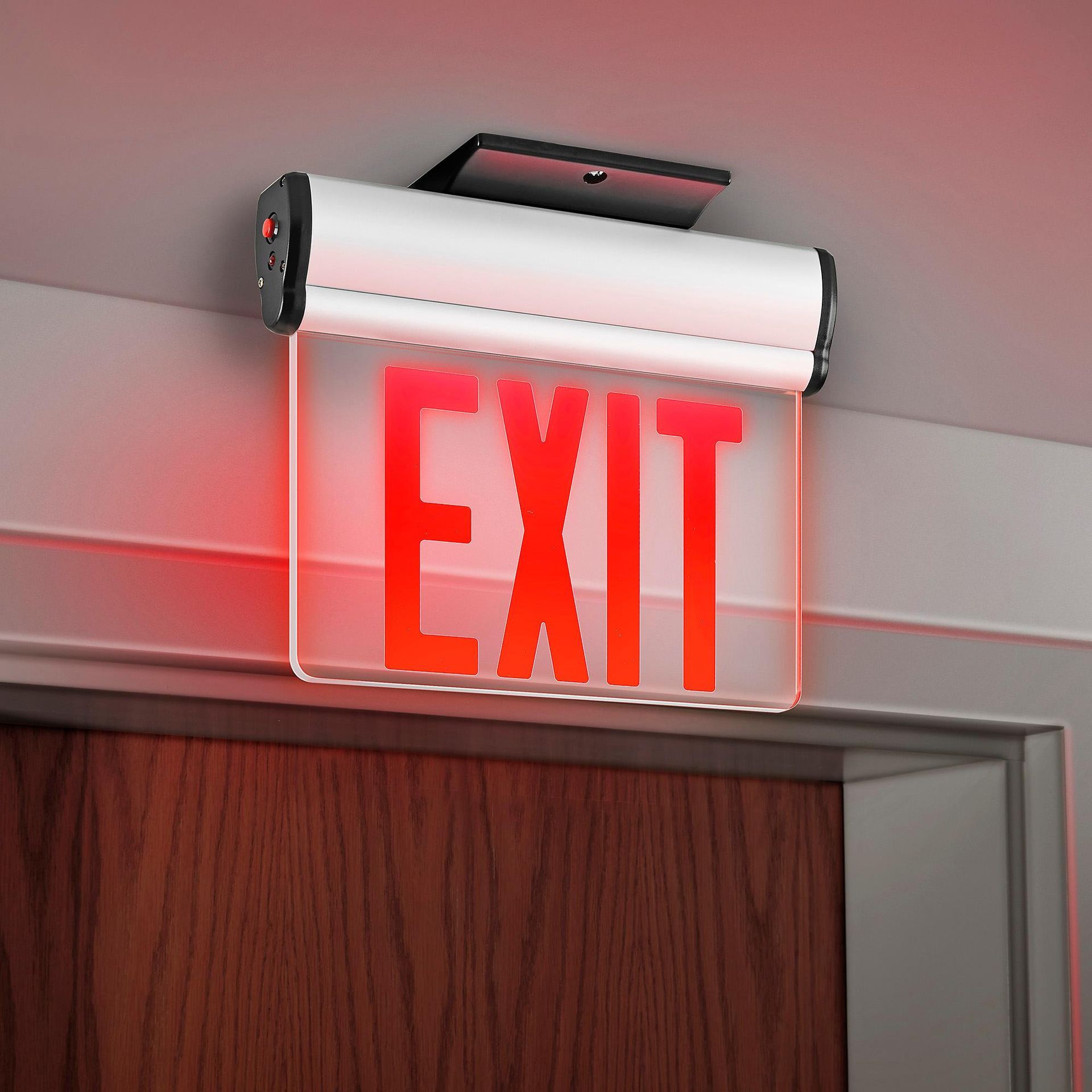 Illuminated red EXIT sign above a doorway on a wall
