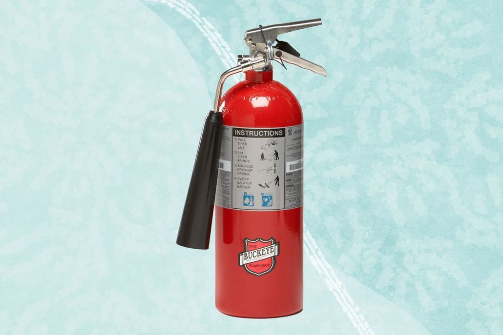 Red fire extinguisher with black hose on a light blue background