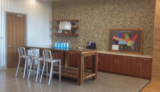 A bar area with bar stools, wooden cabinetry, and a U.S. map on the wall.