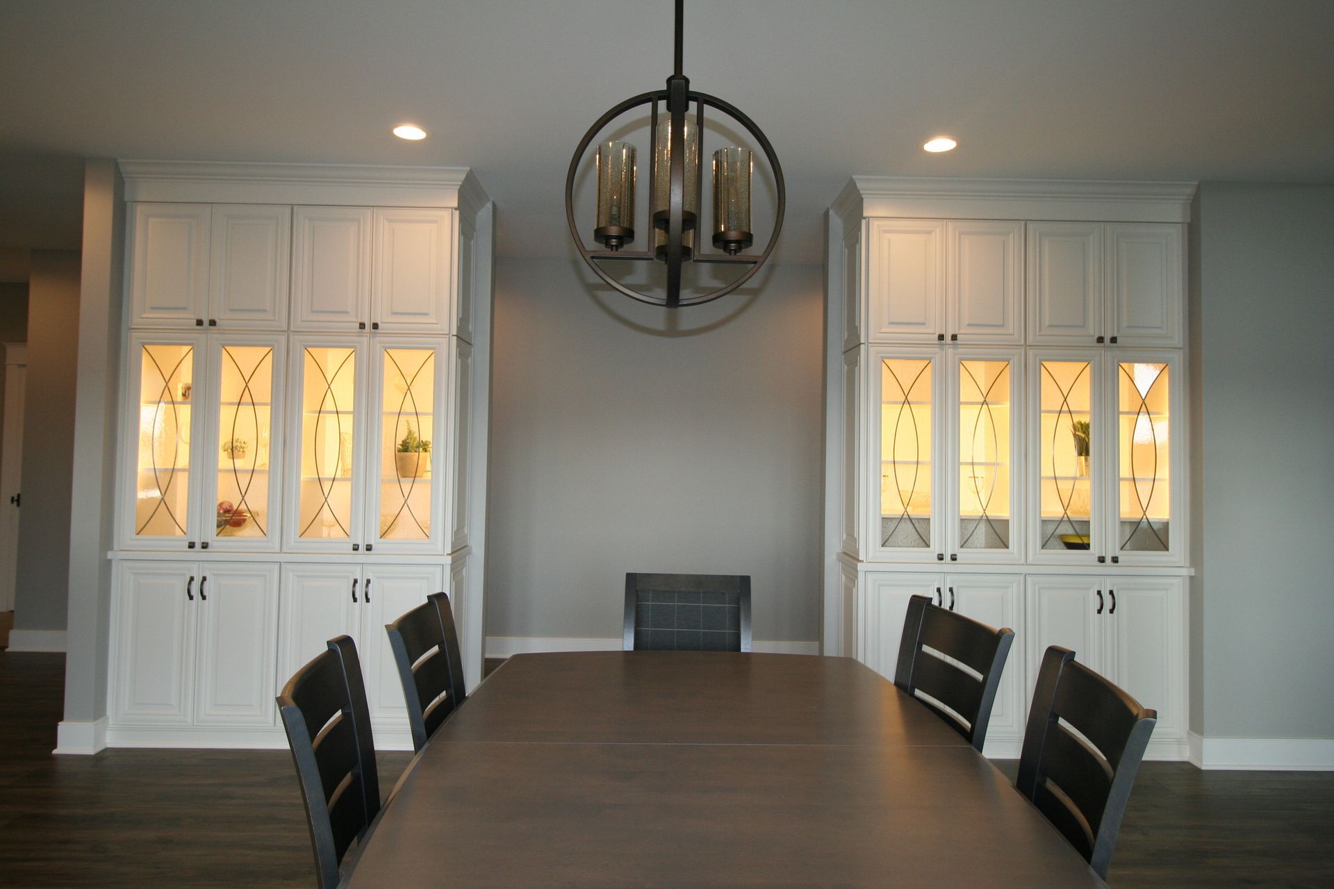 Dining room with a table, chairs, cabinets, and a chandelier.