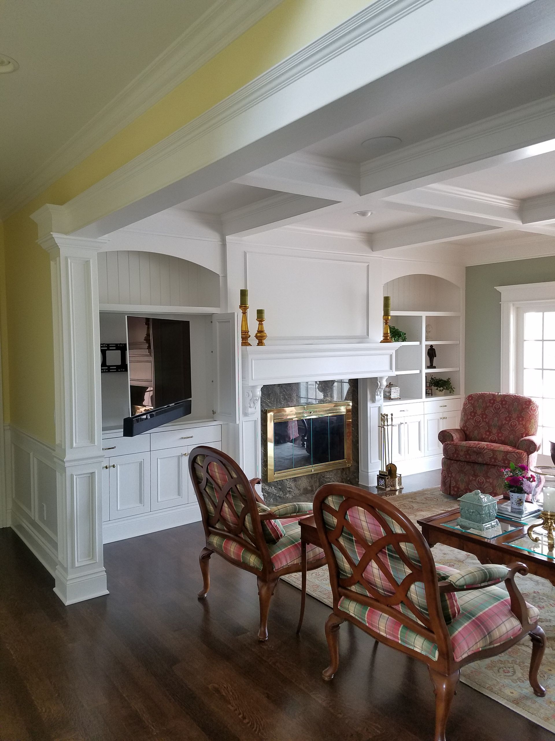 Living room with a fireplace, built-ins, and two decorative chairs.