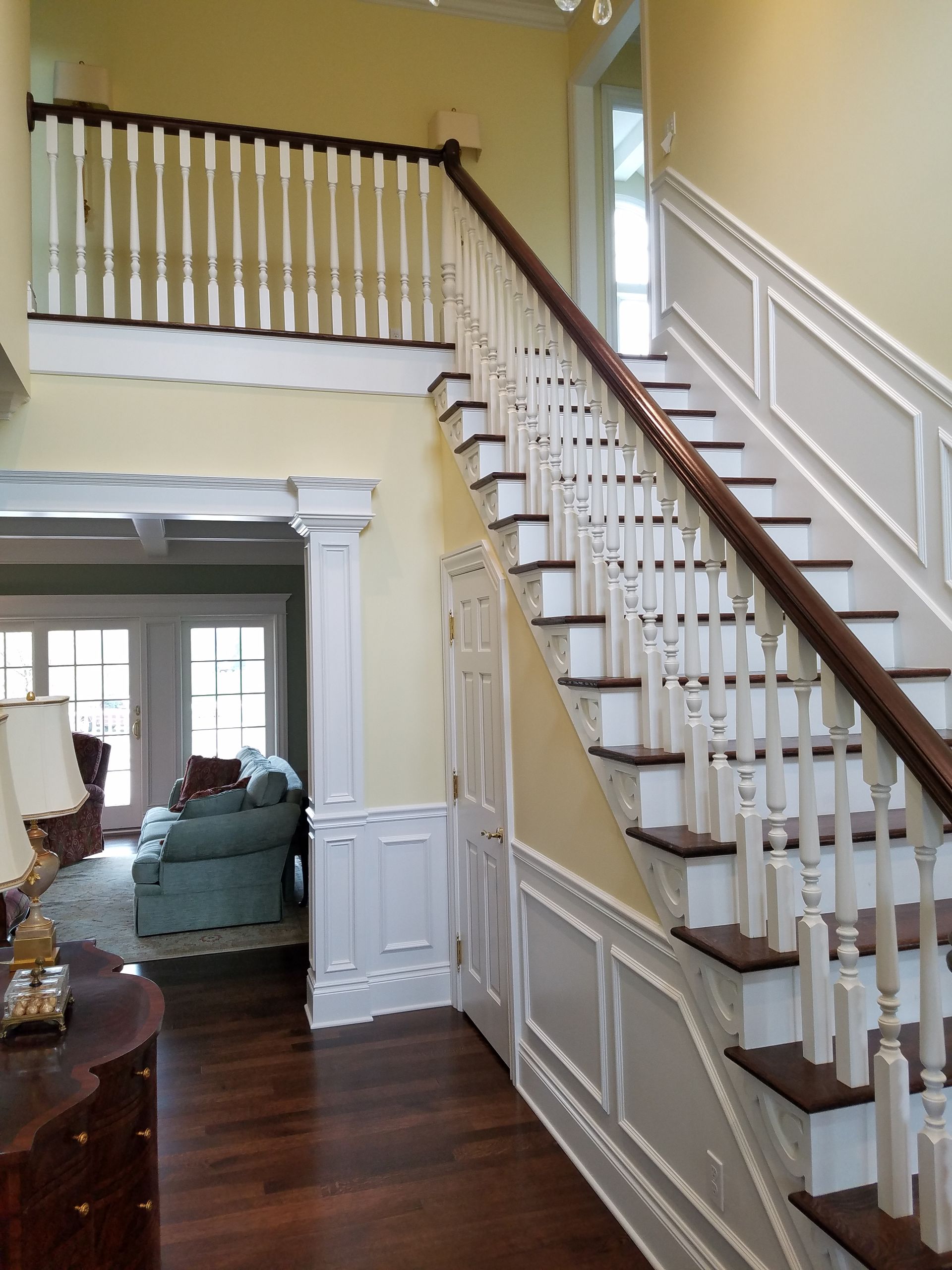 Staircase in a home with dark wood steps, white railings, and light yellow walls.