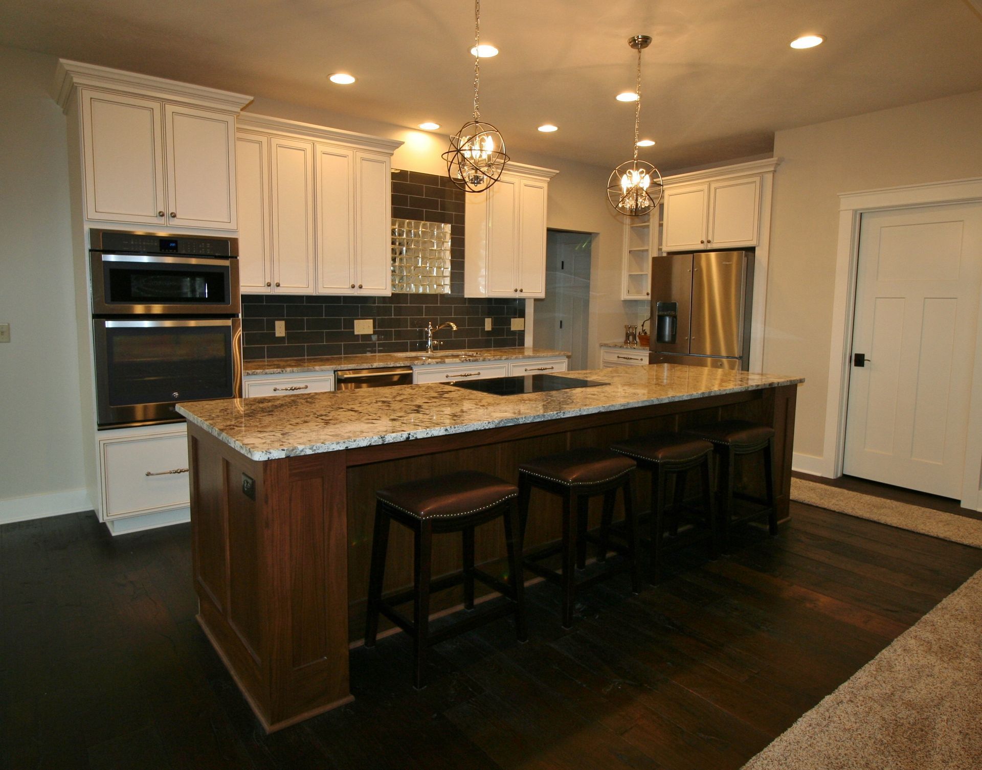 Kitchen with white cabinets, dark wood island, and stainless steel appliances.