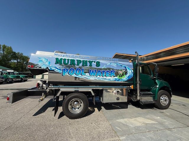 A murphy 's pool water truck is parked in a parking lot.