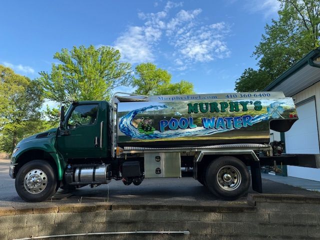 A Murphy's pool water truck is parked in front of a building.