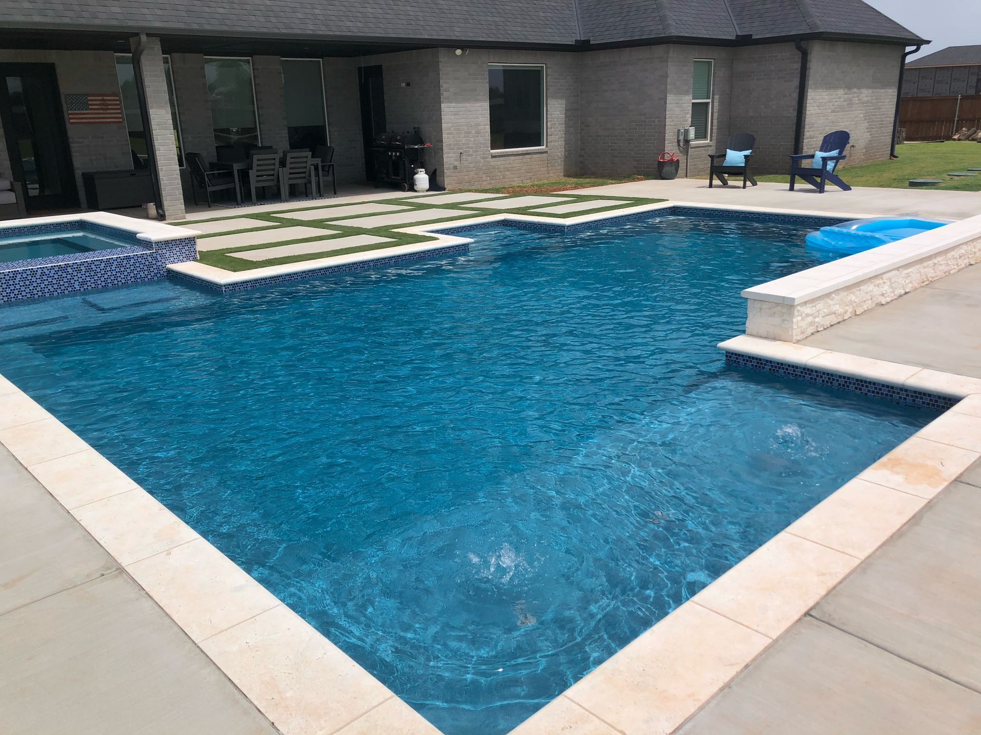 there is a large swimming pool in the backyard of a house