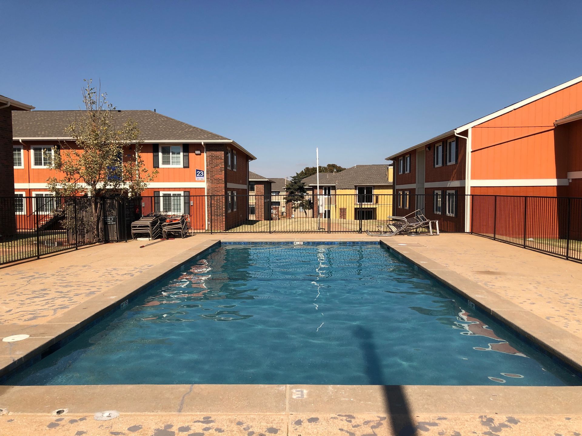 a large swimming pool is surrounded by buildings in a residential area