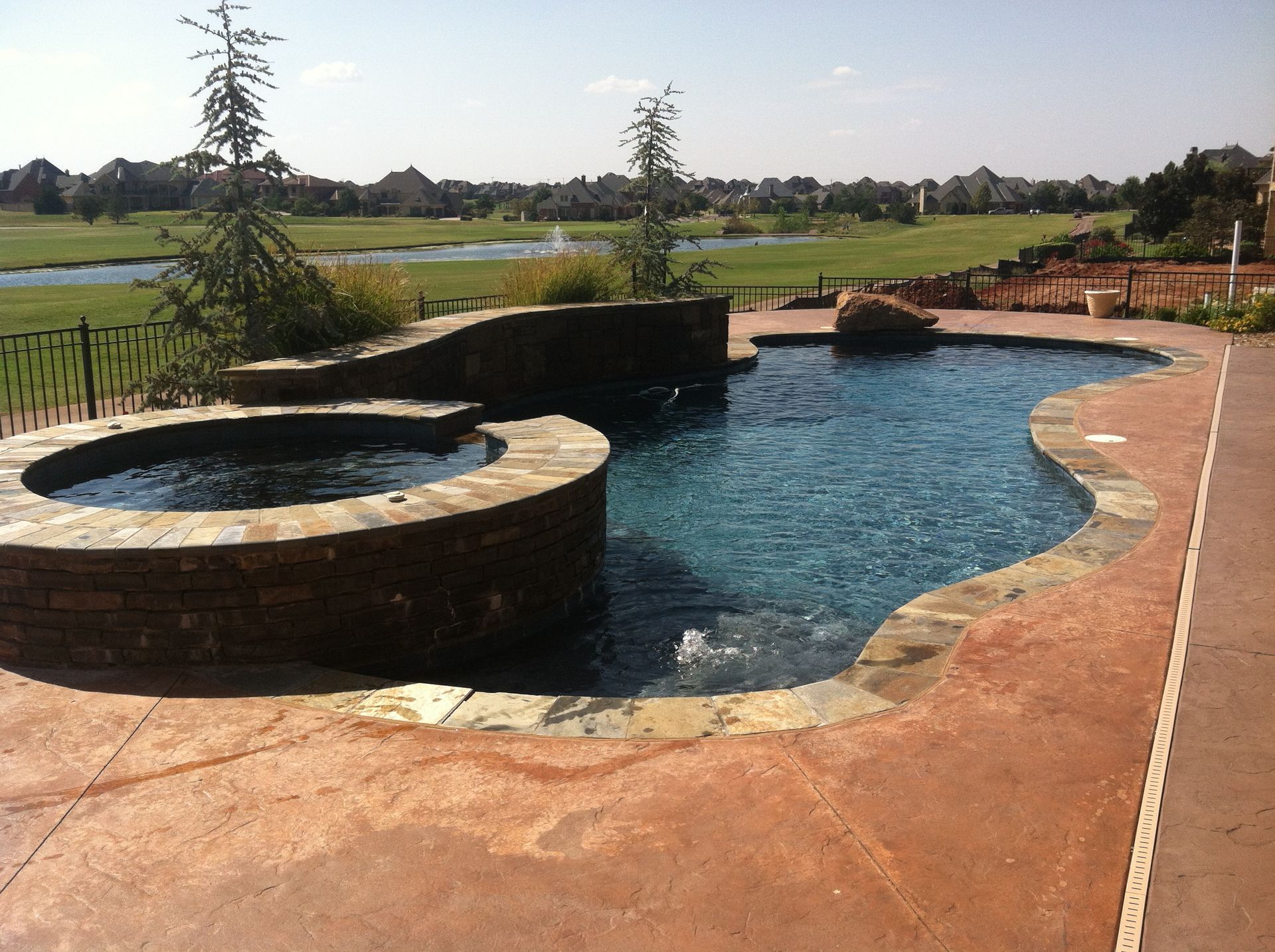 a large swimming pool with a hot tub next to it