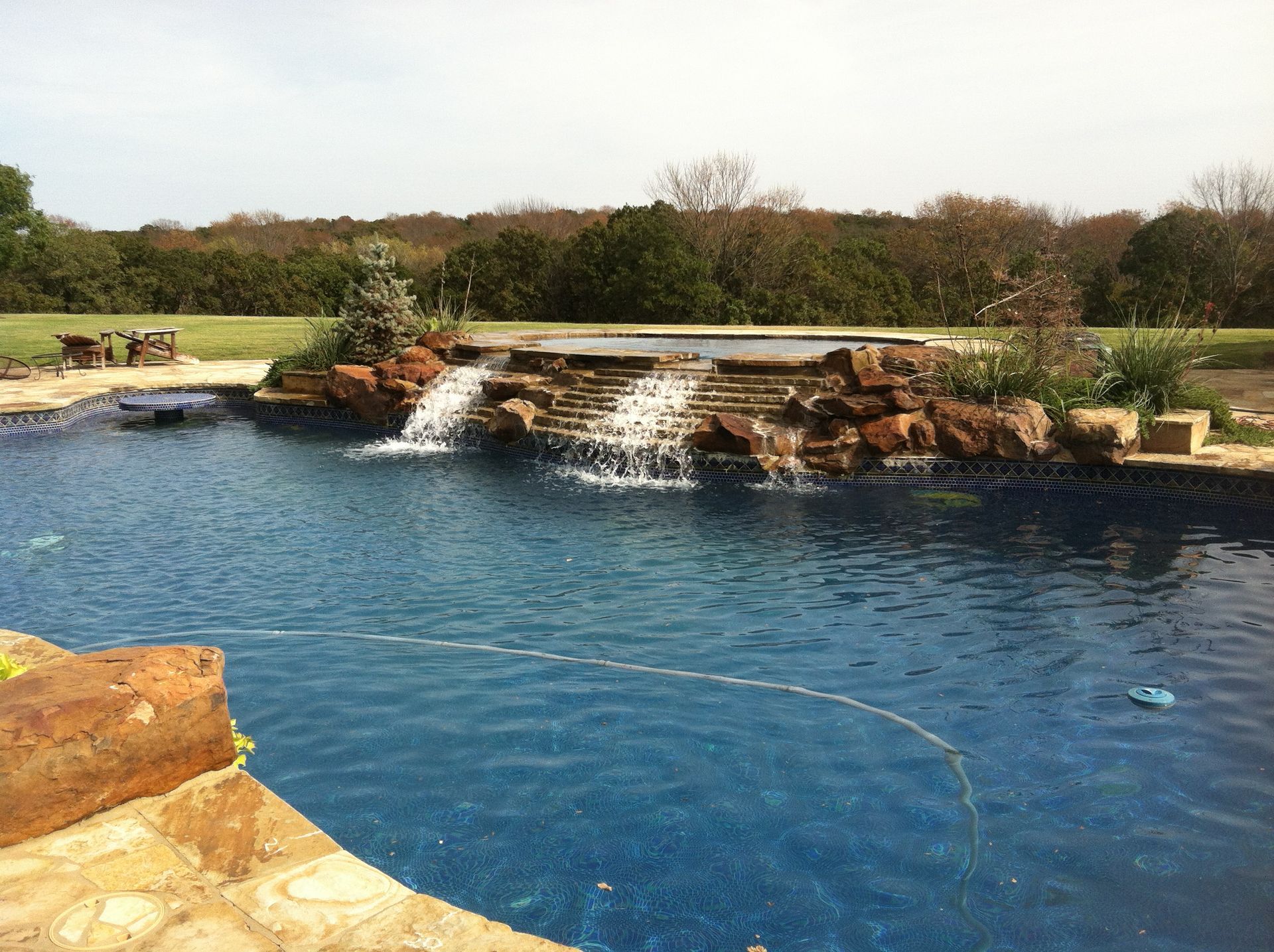 a large swimming pool with a waterfall in the middle of it