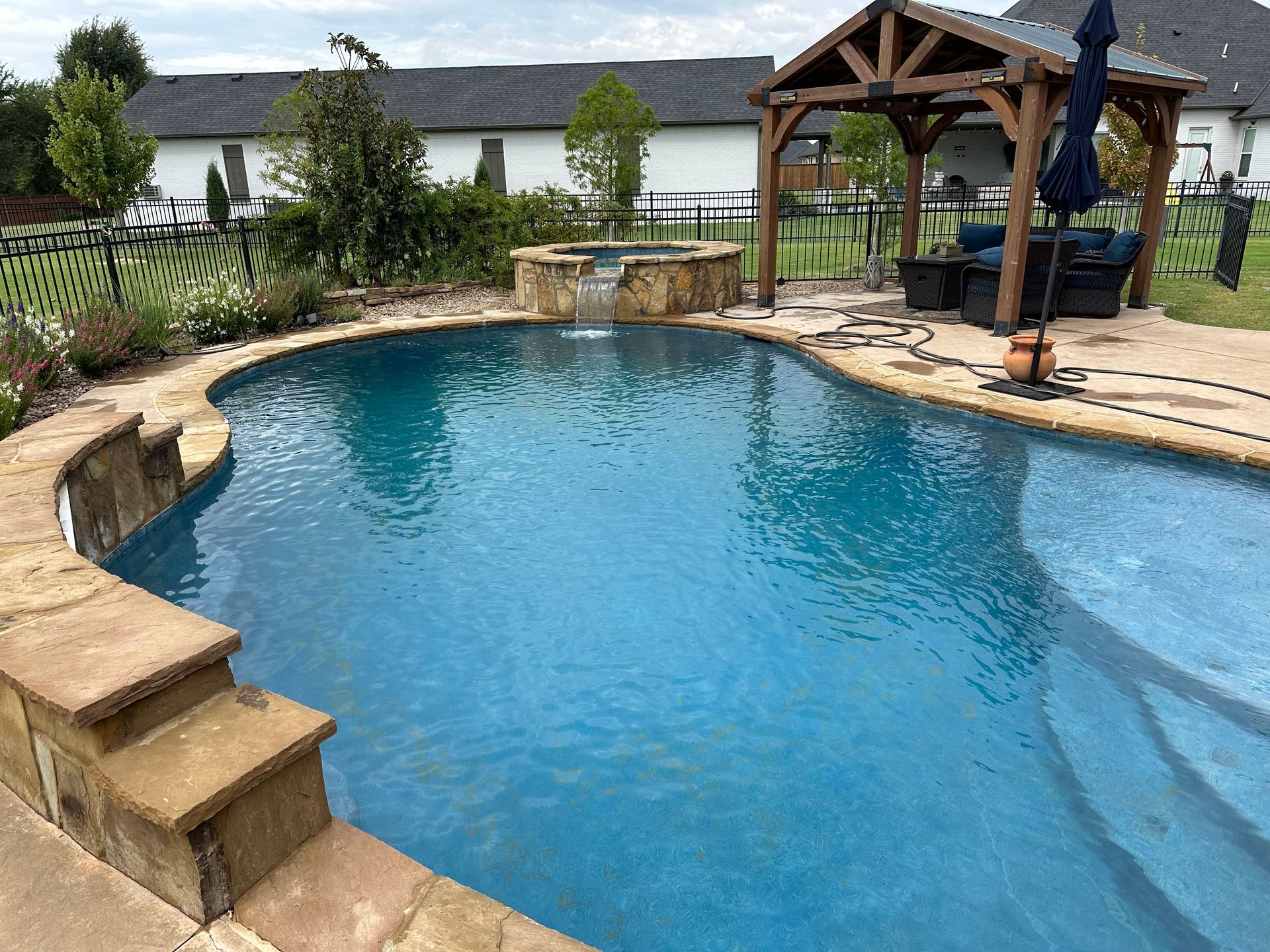 a large swimming pool with a gazebo in the backyard