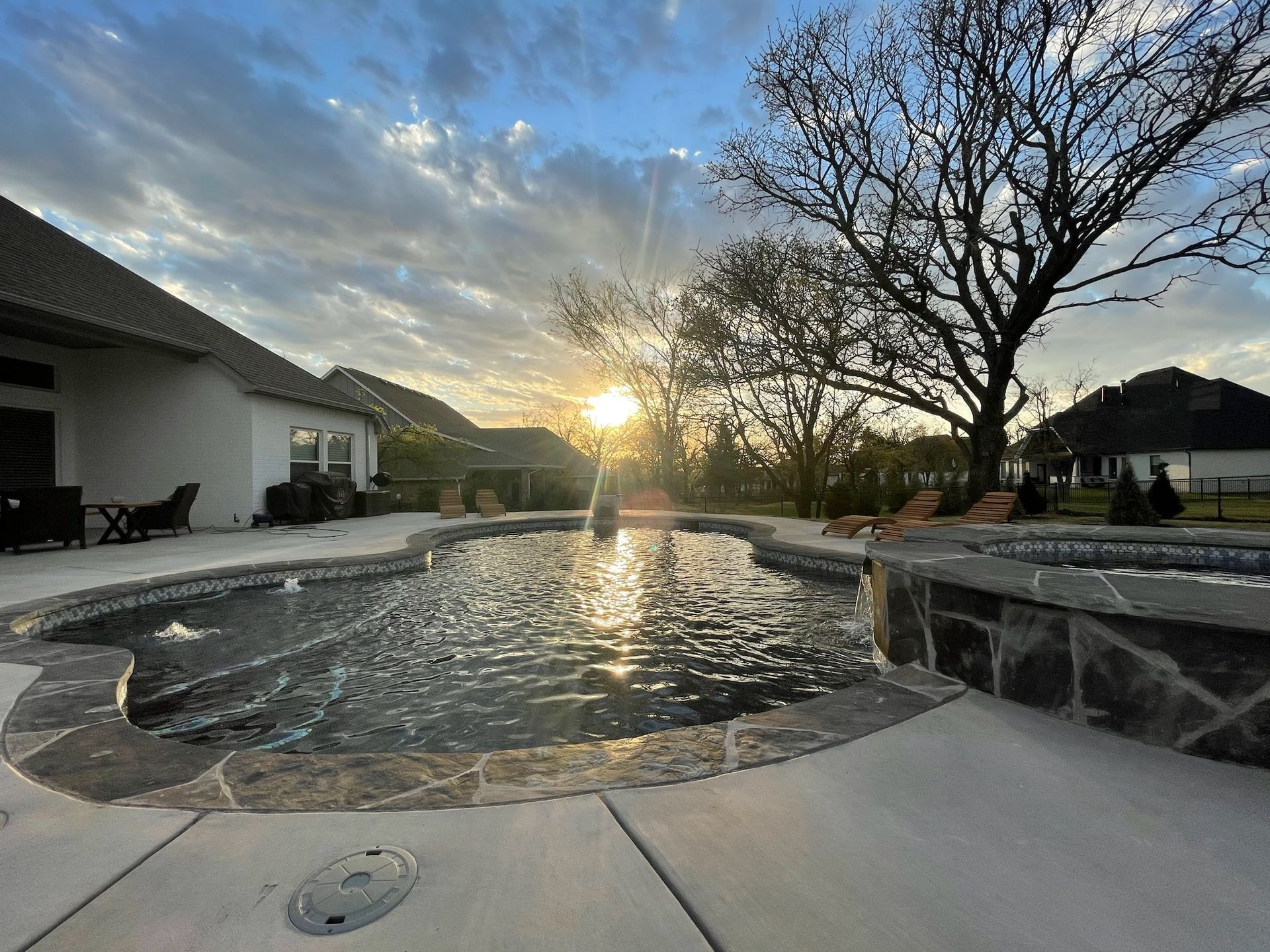 the sun is shining through the clouds over a swimming pool