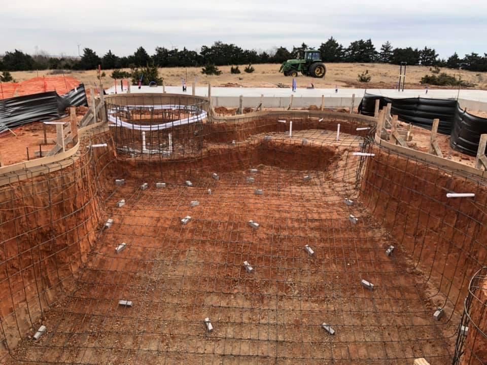 a large swimming pool is being built with a tractor in the background