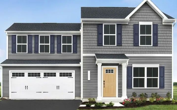 Two-story house with gray siding, blue shutters, and a white garage door. Light brown door.
