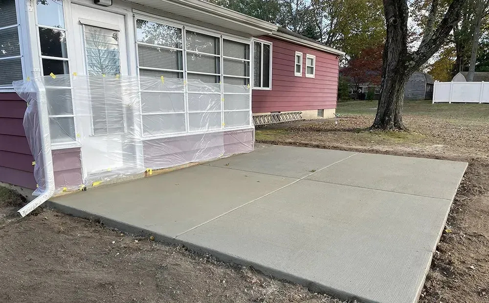 Concrete patio slab beside a screened porch on a residential house