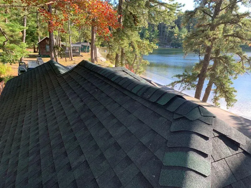 a roof with a view of a lake and trees in the background .