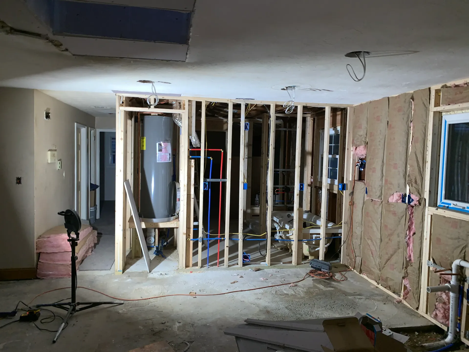 a room that is being remodeled with a water heater in it .