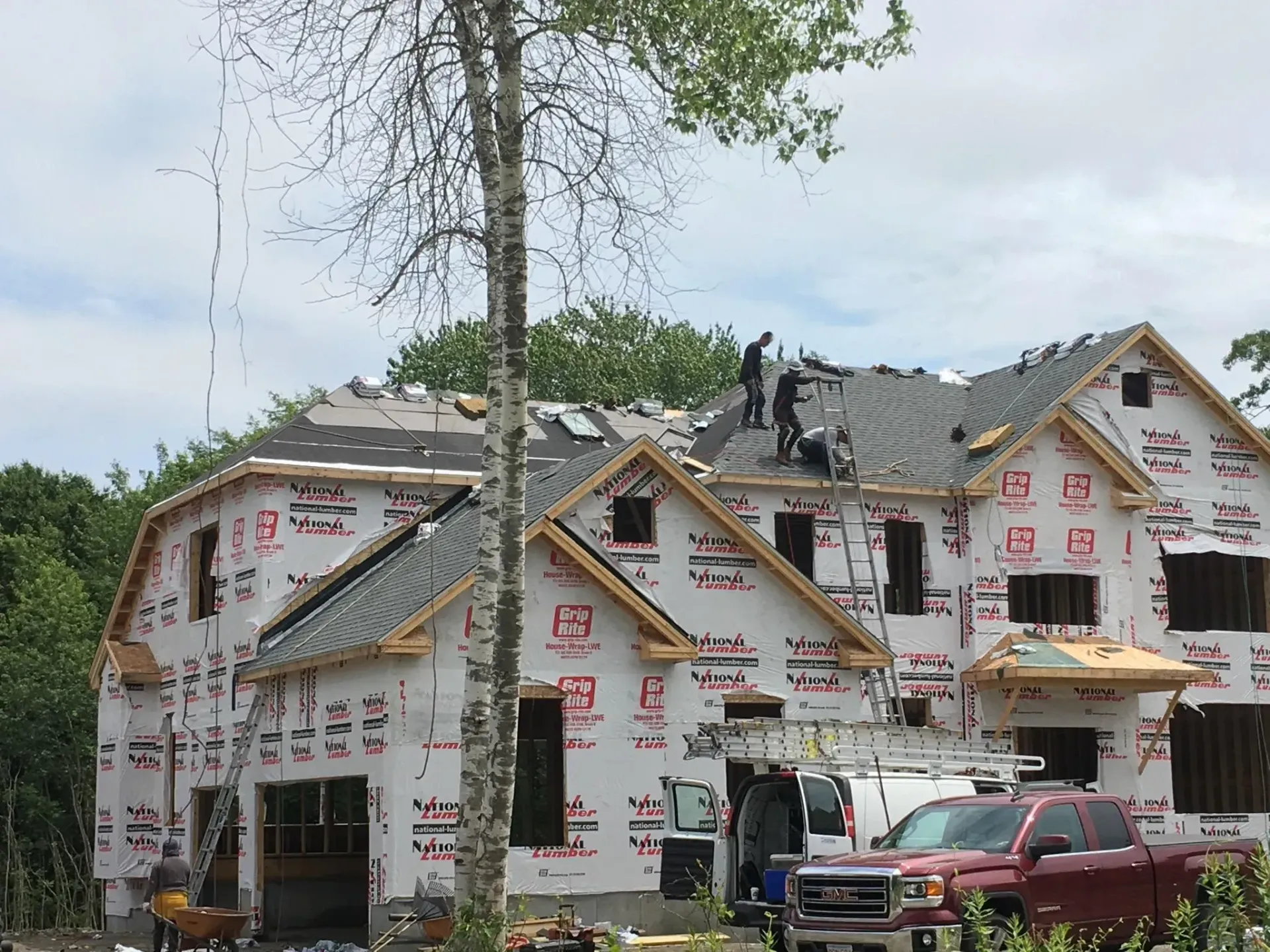 a large house under construction with a red truck parked in front of it