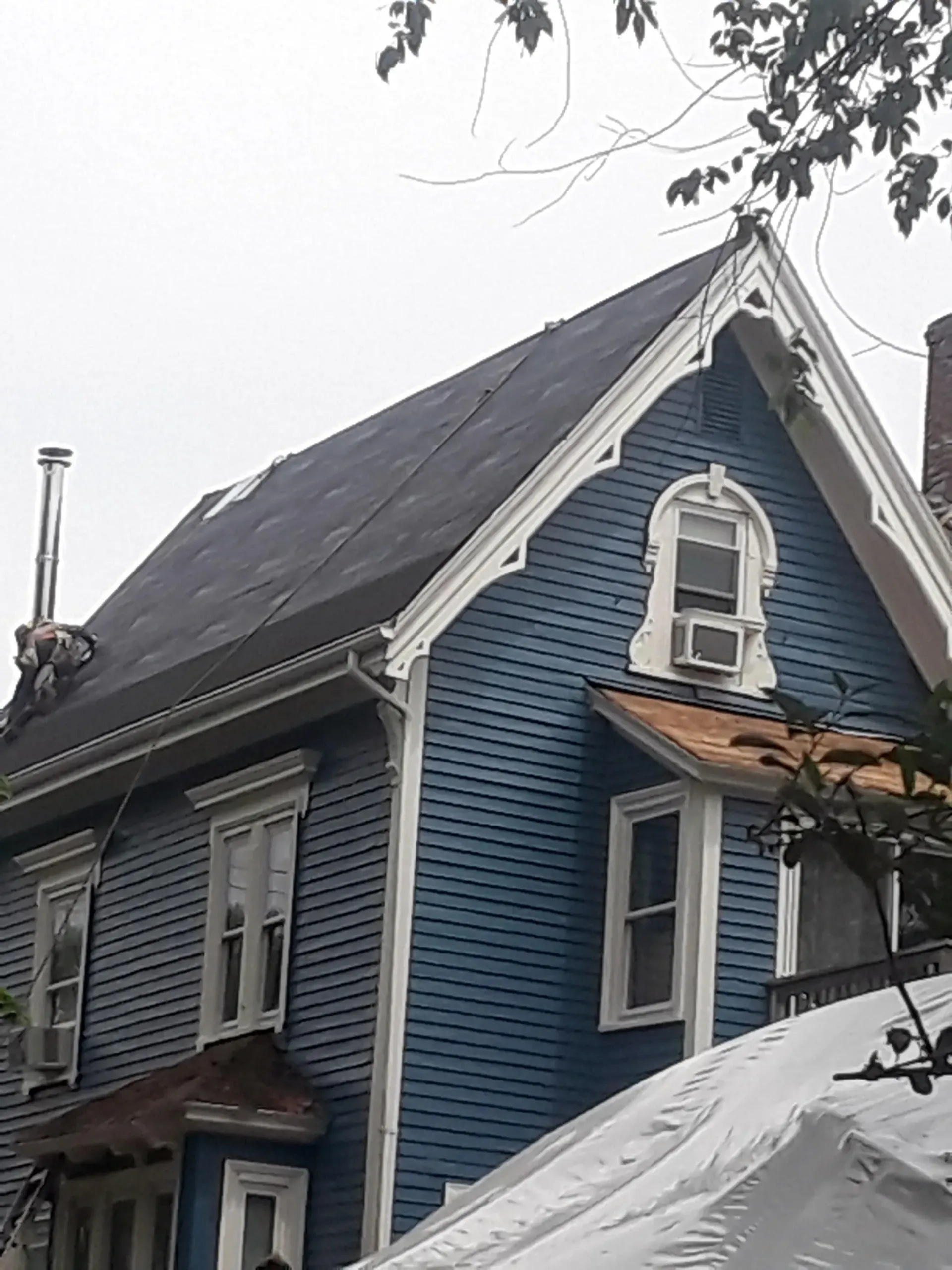 a blue house with a roof that is covered in snow