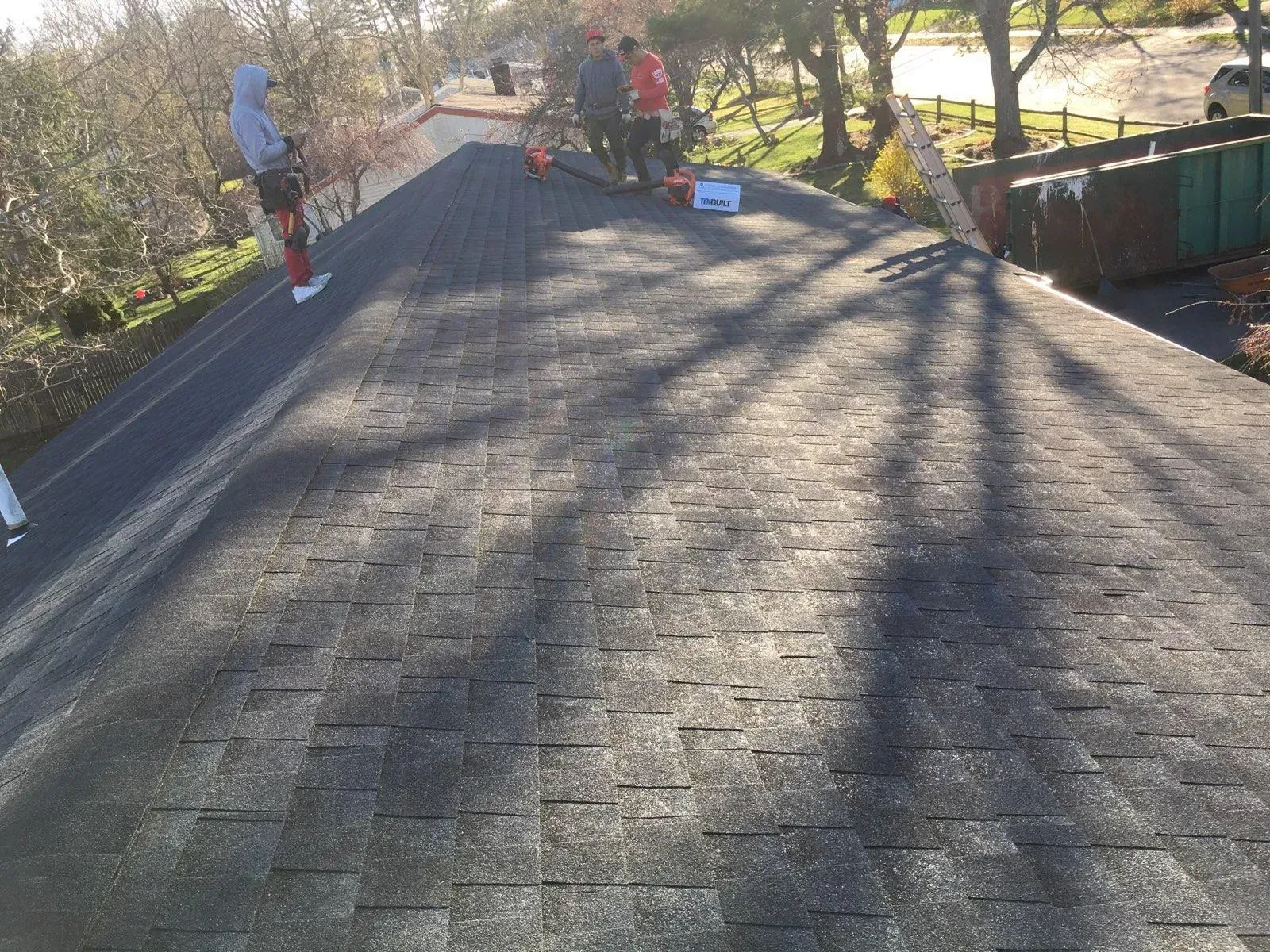a group of people are standing on top of a roof .