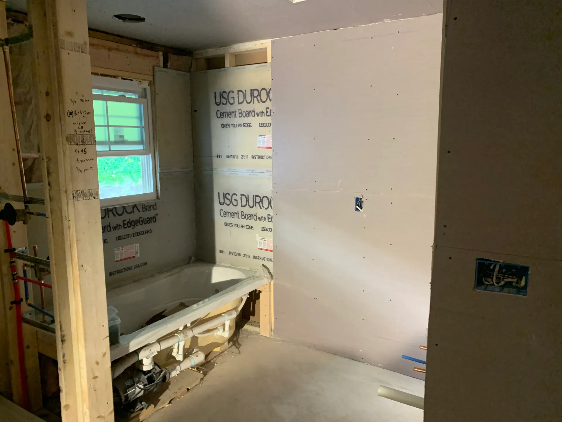 a bathroom under construction with a bathtub and a window .
