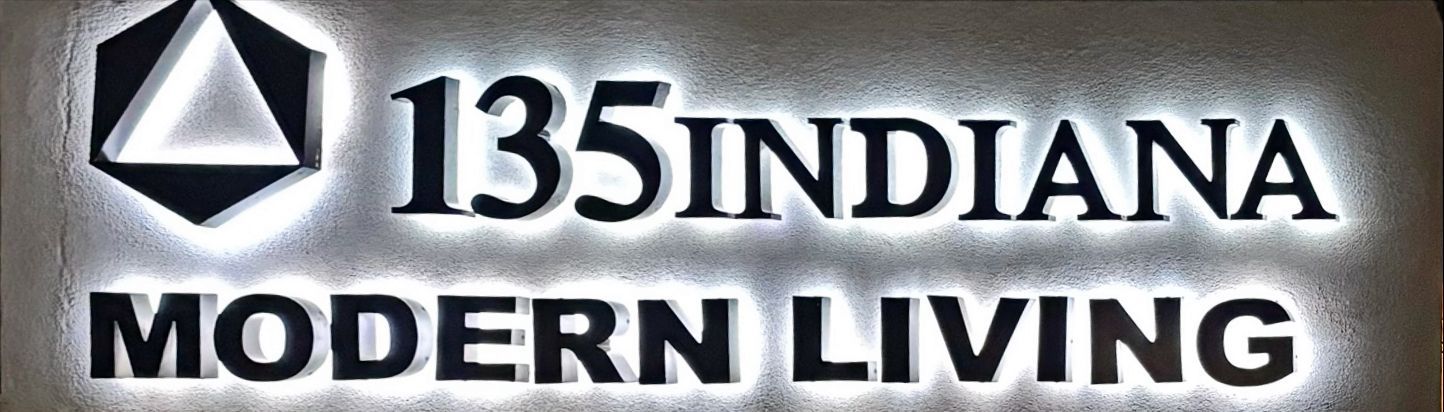 Sign for 135 Indiana Modern Living with a logo and backlit lettering.